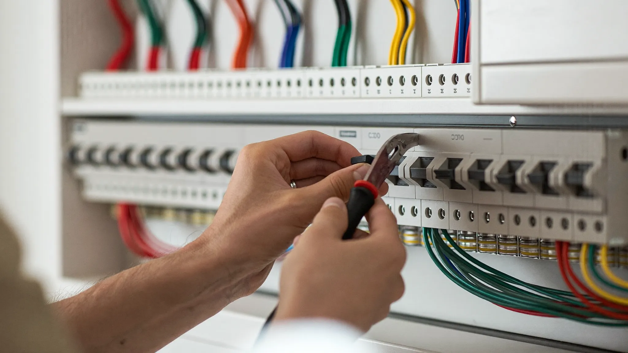 Electricista apretando los automáticos de un cuadro eléctrico nuevo a normativa en Sant Cugat del Vallès